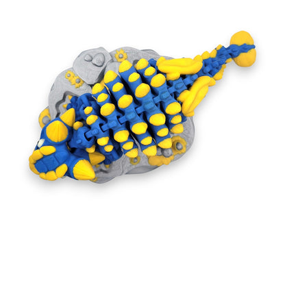 Rear view of the Skeleton Ankylosaurus showing its iconic tail club and articulated vertebrae over a rocky terrain base.